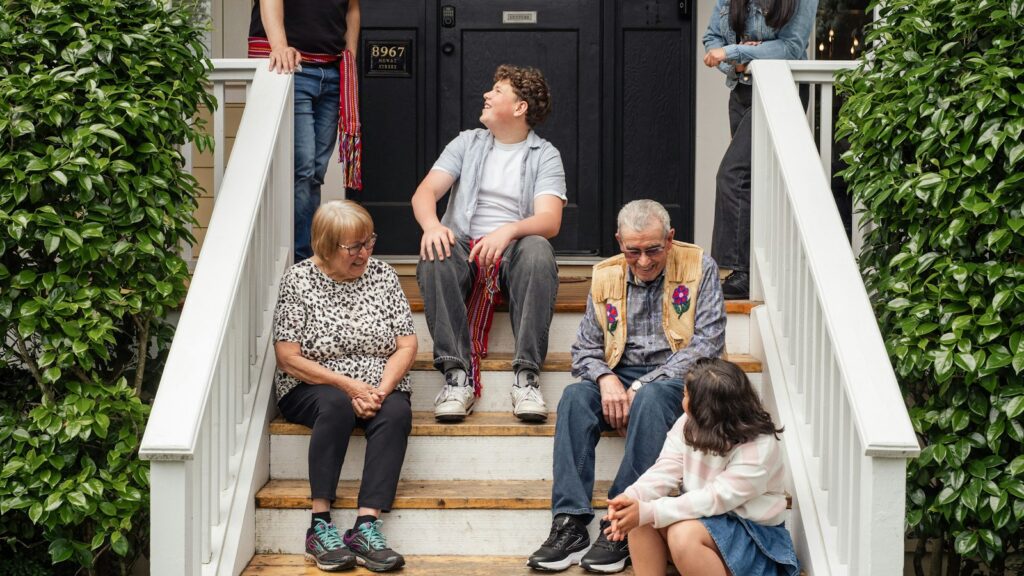 A family sitting together on the front steps of a house