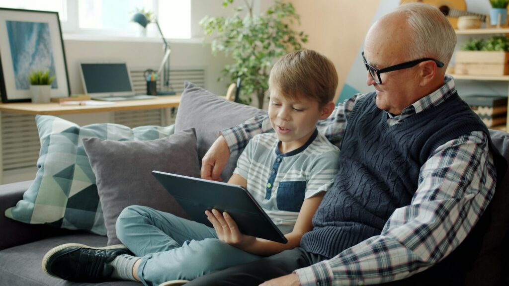 A grandfather and grandson looking at a tablet together